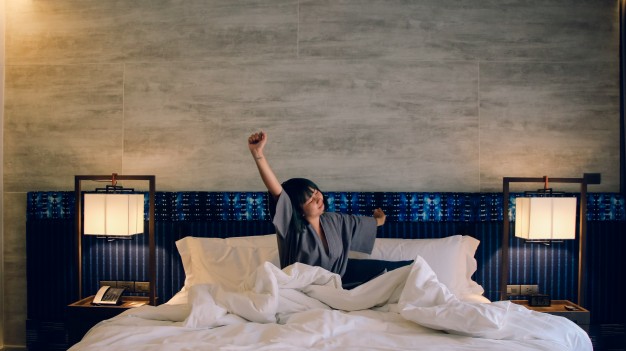 asian-women-wake-up-from-sleep-are-stretch-herself-in-the-morning-on-the-weekend-sit-on-the-bed-at-luxury-room-in-relax-and-weekend-concept_1253-1031