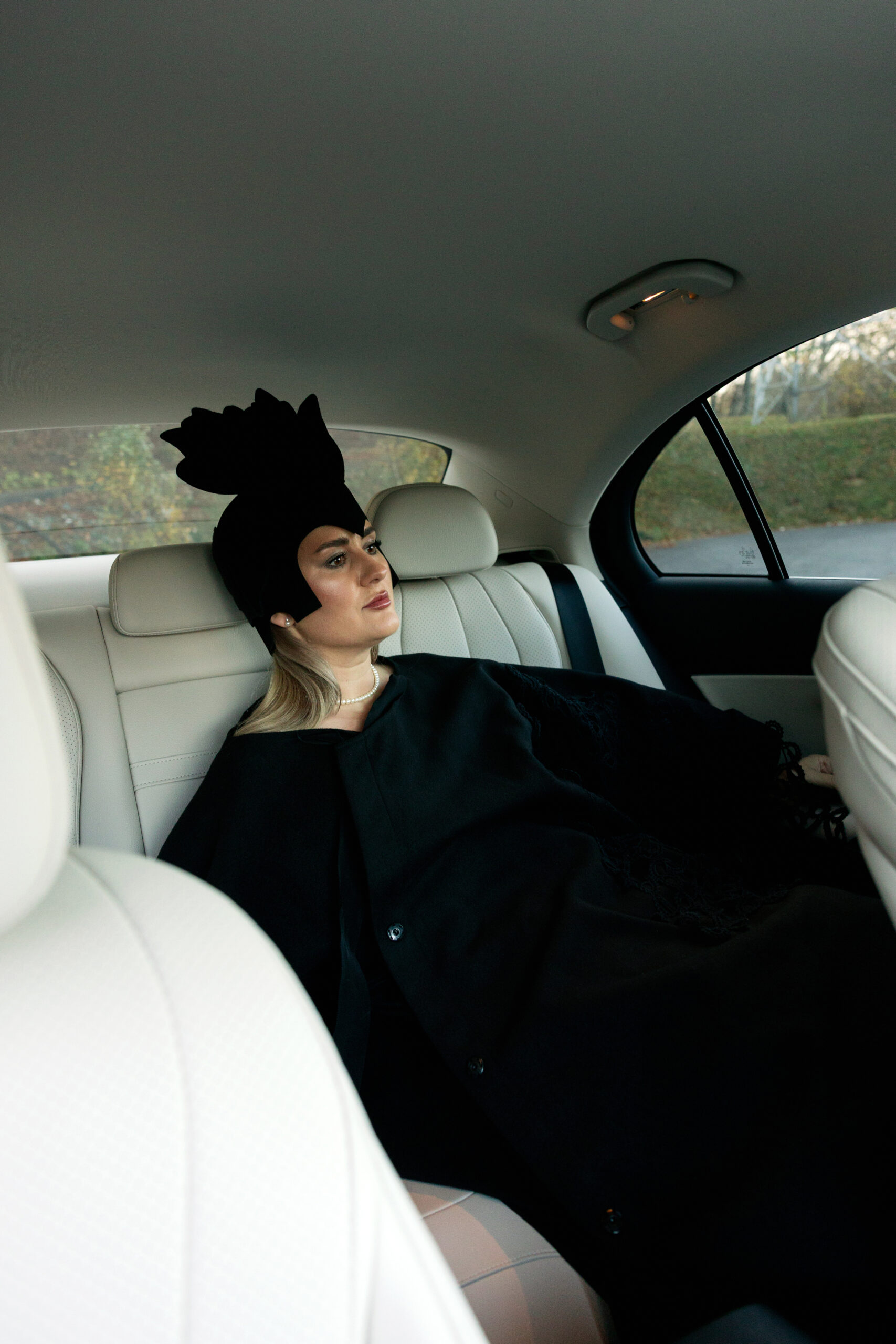 În imagini, personajul stă în spate — o alegere naturală pentru cineva obișnuit să lucreze în mișcare, să se pregătească pentru un eveniment, sau pur și simplu să își protejeze timpul și energia între întâlniri.